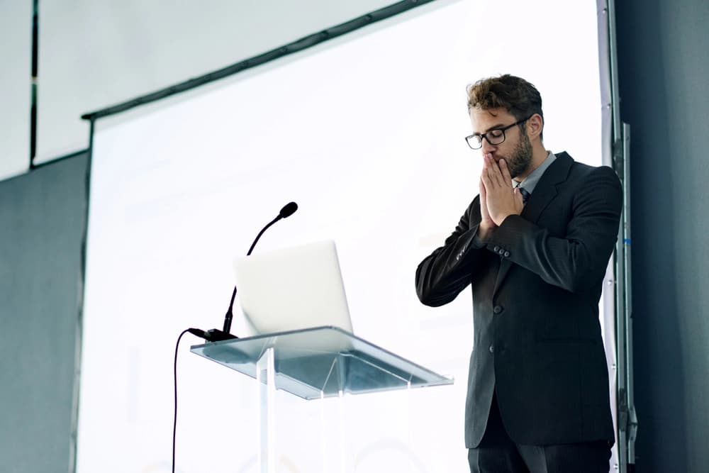 A coach speaking to an audience in a conference room